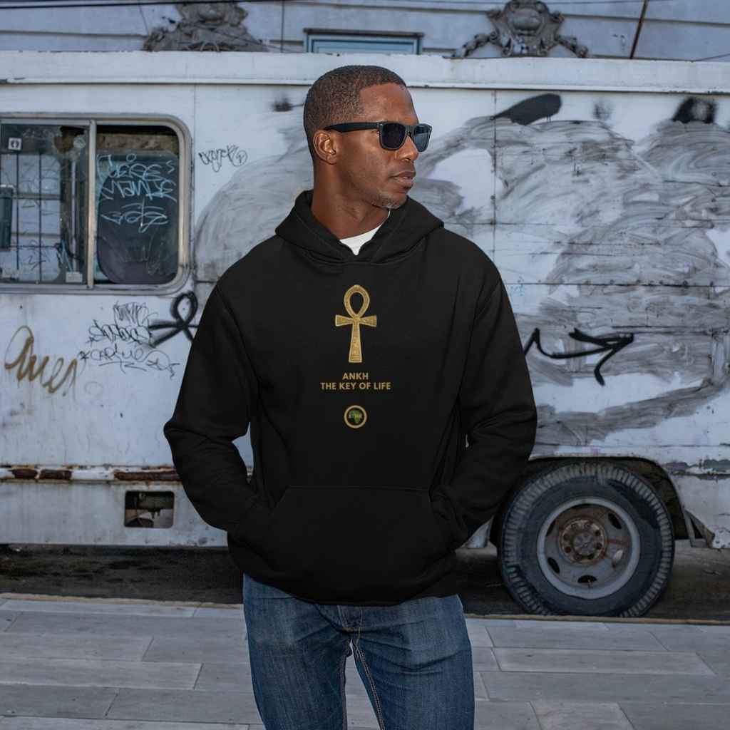 Adult black male model wearing a Black personalised hoodie, with a large gold Ankh symbol on the centre of the hoodie, with the words Ankh, The Key of Life with a small BTMR Round Logo underneath. Model has his hand in his pockets, and is wearing sunglasses