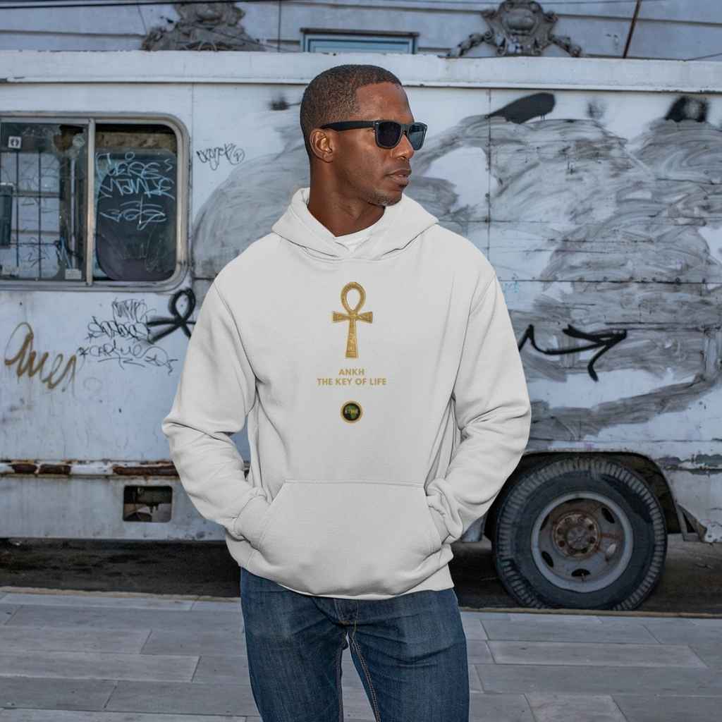 Adult black male model wearing a heather grey personalised hoodie, with a large gold Ankh symbol on the centre of the hoodie, with the words Ankh, The Key of Life with a small BTMR Round Logo underneath. Model has his hand in his pockets, and is wearing sunglasses