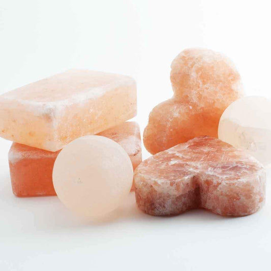 Picture of approximately 6 different bars of Himalayan Salt Soap. These are a combination of Pink Himalayan Salt soap and a lighter white looking salt soap. In a variety of shapes and sizes, 2 rectangular bars of Pink Himalayan Salt Soap, 2 Heart Shaped Pink Himalayan Salt Soaps ad 2 pale balls of himalayan salt soap