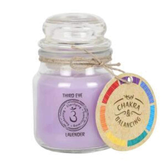 Balancing Chakra Candle in a min glass jar with stopper. Tied with a label that says Chakra Balancing. Candle is purple with a label on the jar that says Third Eye - Lavender